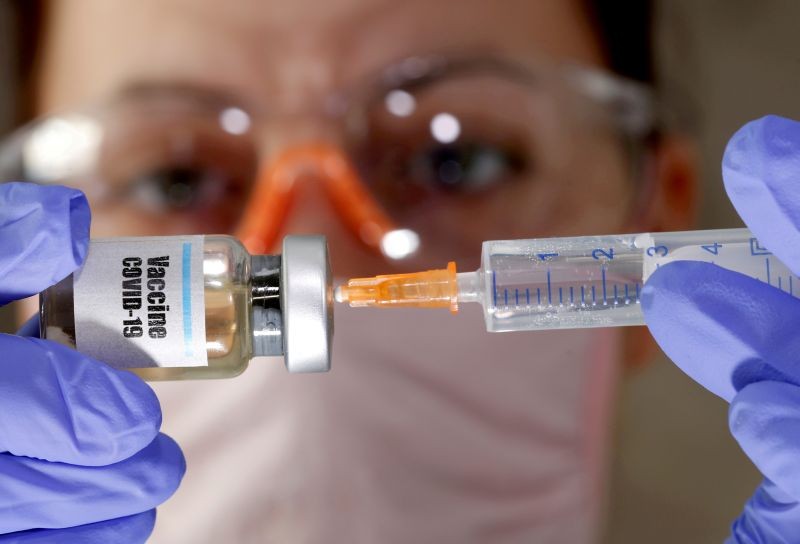 A woman holds a small bottle labeled with a "Vaccine COVID-19" sticker and a medical syringe in this illustration taken April 10, 2020. (REUTERS File Photo)