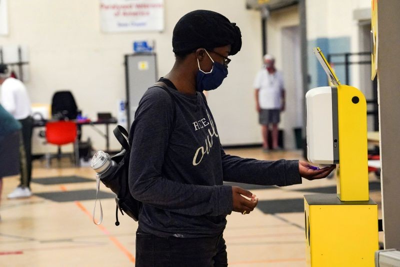 FILE PHOTO: A voter sanitizes her hand after casting a ballot for the upcoming presidential election as early voting begins in Houston, Texas, U.S., October 13, 2020. REUTERS/Go Nakamura/File Photo/File Photo