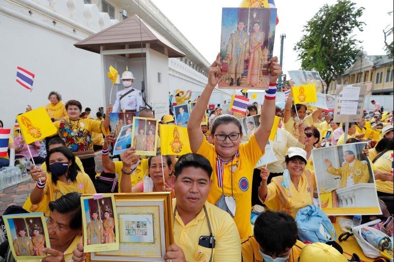 Supporters of Thailand's King Maha Vajiralongkorn and Queen Suthida hold pictures of them, as they gather before a religious ceremony, at The Grand Palace in Bangkok, Thailand, November 1, 2020. (REUTERS Photo)