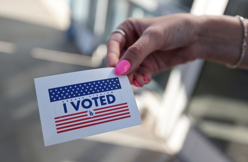 A person holds an "I voted" sticker as people vote in the U.S. presidential election on the first day of expanded California in-person voting, amid the global outbreak of the coronavirus disease (COVID-19), at Dodger Stadium sports venue in Los Angeles, California, U.S., October 30, 2020. (REUTERS File Photo)