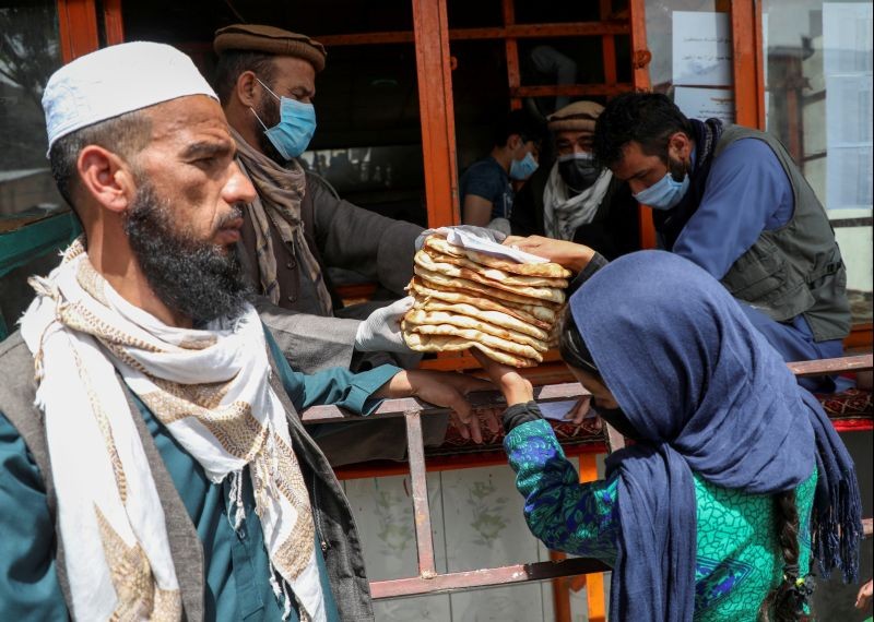 An Afghan girl receives free bread distributed by the government, outside a bakery, during the coronavirus disease (COVID-19) outbreak in Kabul, Afghanistan May 3, 2020. Picture taken May 3, 2020. (REUTERS File Photo)