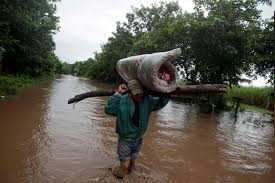 A man carries his belongings through a flooded road after the passing of Storm Iota, in Marcovia, Honduras November 18, 2020. REUTERS/Jorge Cabrera