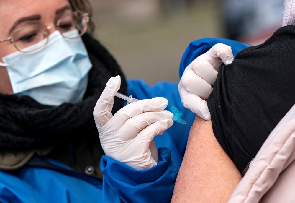 FILE PHOTO: A member of nursing staff vaccinates a person against influenza as vaccination to high risk group patients is administered outdoors to prevent the spread of the coronavirus disease (COVID-19), in Trelleborg, southern Sweden November 19, 2020. TT News Agency/Johan Nilsson via REUTERS