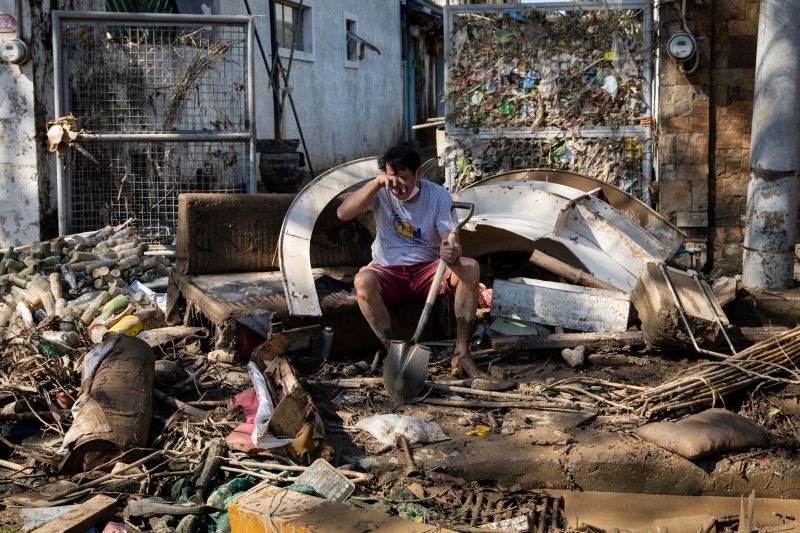 A man reacts as he takes a break from cleaning mud outside his house, which was submerged due to floods caused by Typhoon Vamco, in Marikina, Metro Manila, Philippines, November 13, 2020. REUTERS/Eloisa Lopez