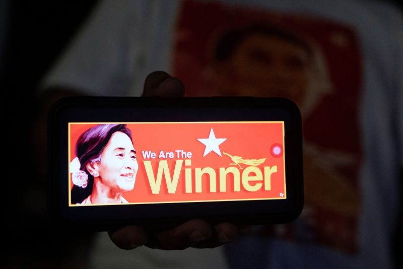 A person shows a picture of Myanmar State Counselor Aung San Suu Kyi on a mobile phone as supporters of the National League for Democracy (NLD) party wait for results outside the party headquarters, after the general election in Yangon, Myanmar, November 8, 2020. (REUTERS Photo)