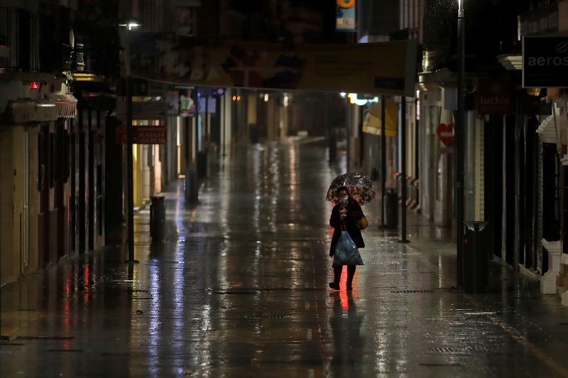 A worker walks along an empty street during the first day of the nighttime curfew set as part of a state of emergency in an effort to control the outbreak of the coronavirus disease (COVID-19), in downtown Ronda, southern Spain, late October 25, 2020. (REUTERS File Photo)