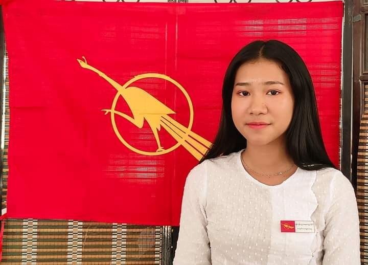 An undated photo shows Hnin, a Myanmar teacher, posing in front of National League for Democracy party flag in Hpakant Township, Kachin State, Myanmar. (REUTERS Photo)