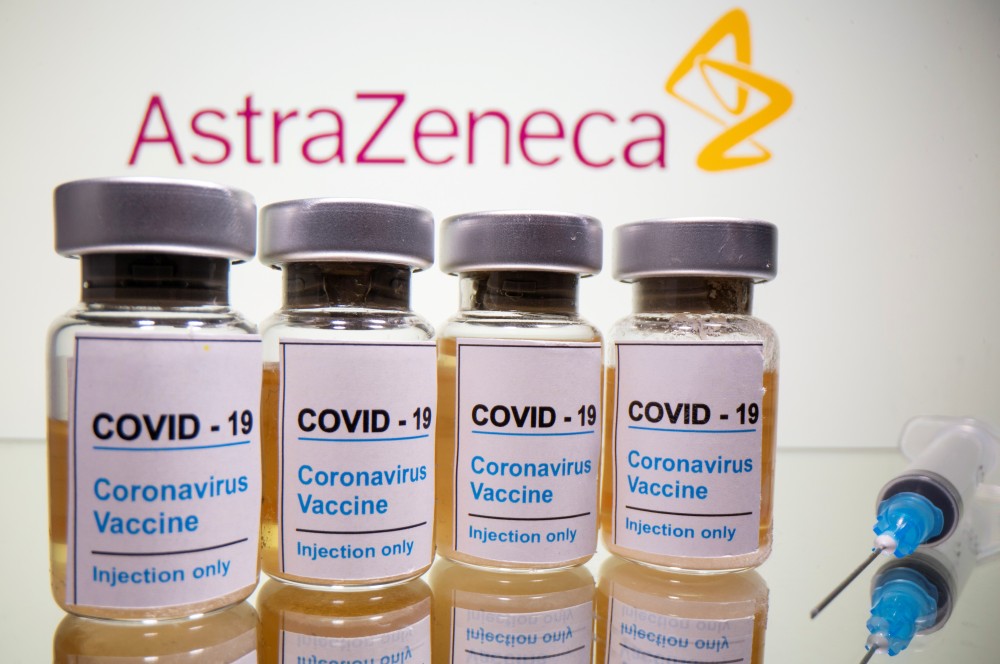 Vials with a sticker reading, "COVID-19 / Coronavirus vaccine / Injection only" and a medical syringe are seen in front of a displayed AstraZeneca logo in this illustration taken October 31, 2020. REUTERS/Dado Ruvic/Illustration/File Photo