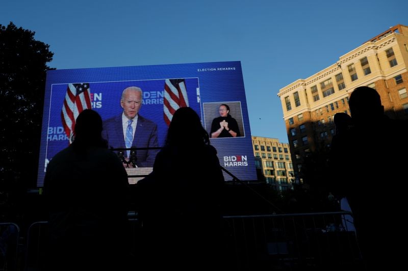 People watch Democratic U.S. presidential nominee and former Vice President Joe Biden speaking during a news conference on a screen, as they wait for the results of the 2020 presidential election in Washington, U.S., November 4, 2020. (REUTERS Photo)