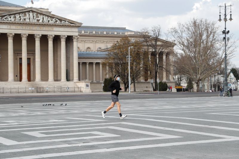 A man wearing a protective face mask runs through an empty Heroes' Square during a curfew restrictions, to prevent the spread of the coronavirus disease (COVID-19), in Budapest, Hungary March 28, 2020. (REUTERS File Photo)