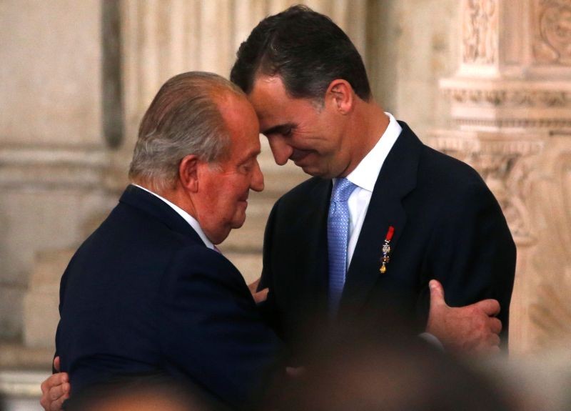 Spain's King Juan Carlos and his son Crown Prince Felipe (R) hug each other as they attend the signature ceremony of the act of abdication at the Royal Palace in Madrid, June 18, 2014. (REUTERS File Photo)
