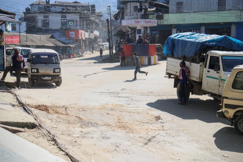 Members of The Gigglers and United Labours Society filling up a pothole with gravel and soil at High School Junction, Tuensang town on November 7. (Morung Photo)