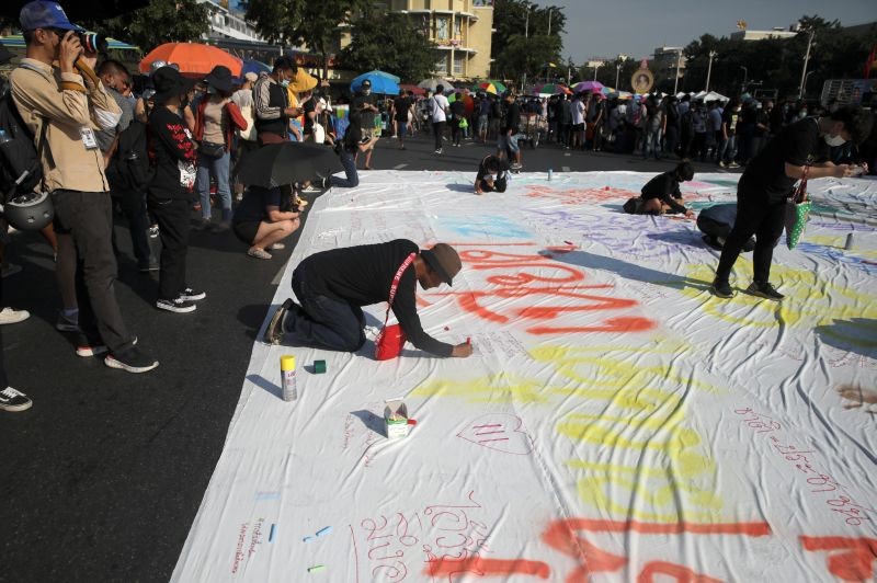 People write on poster during a rally to call for the ouster of Prime Minister Prayuth Chan-ocha's government and reforms in the monarchy in Bangkok, Thailand, November 14, 2020. (REUTERS Photo)