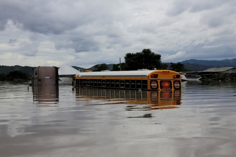 A patrially submerged bus is seen next to flooded houses during the passage of Storm Eta, in Pimienta, Honduras November 5, 2020. (REUTERS Photo)