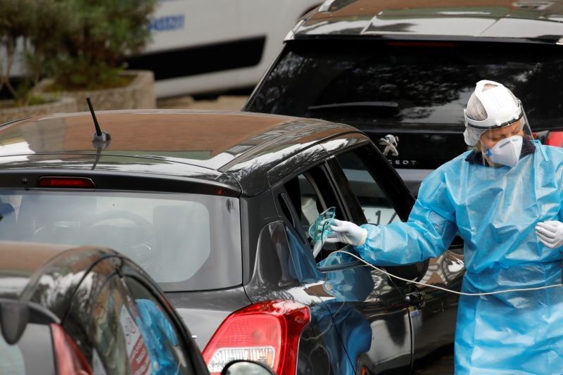 A medical worker gives an oxygen mask to a patient in a car, as people in cars line up for treatment outside the Cotugno hospital, amid the outbreak of the coronavirus disease (COVID-19), in Naples, Italy, November 12, 2020. (REUTERS Photo)