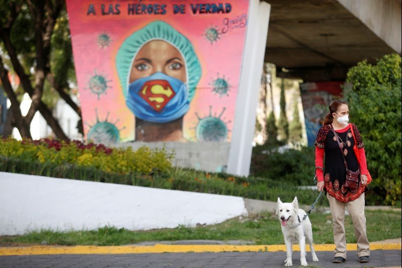 A woman and her dog are pictured in front a mural in honor to health workers as the coronavirus disease (COVID-19) outbreak continues, in Mexico City, Mexico November 7, 2020. (REUTERS Photo)