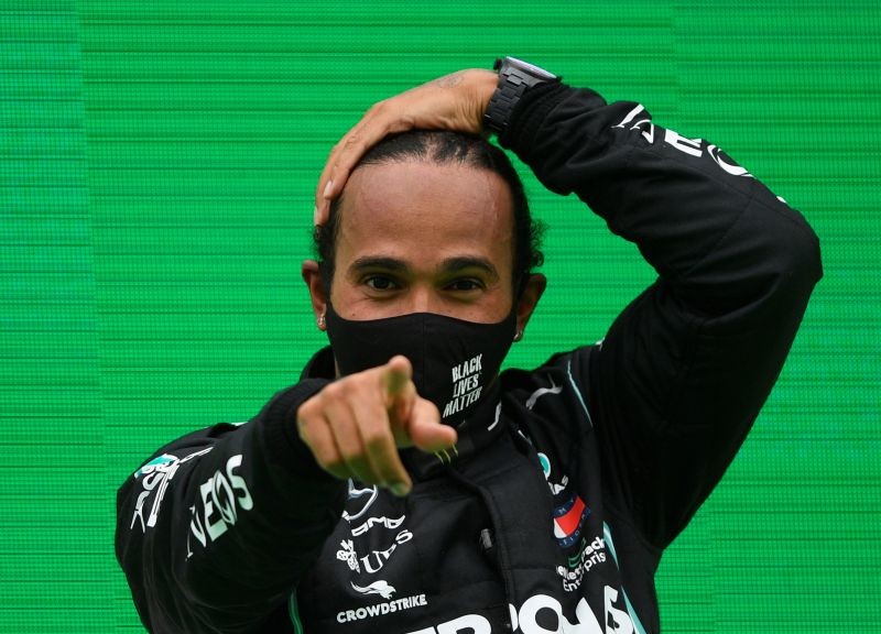 FILE PHOTO: Formula One F1 - Portuguese Grand Prix - Algarve International Circuit, Portimao, Portugal - October 25, 2020 Mercedes' Lewis Hamilton celebrates winning the race on the podium Pool via REUTERS/Rudy Carezzevoli