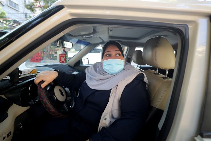 Palestinian woman Naela Abu Jibba, who started a women-only taxi service in Gaza Strip, sits behind the wheel of her vehicle at Beach refugee camp in Gaza City November 17, 2020. (REUTERS Photo)