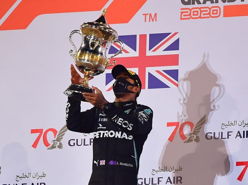 Formula One F1 - Bahrain Grand Prix - Bahrain International Circuit, Sakhir, Bahrain - November 29, 2020 Mercedes' Lewis Hamilton celebrates with a trophy on the podium after winning the race Pool via REUTERS/Giuseppe Cacace