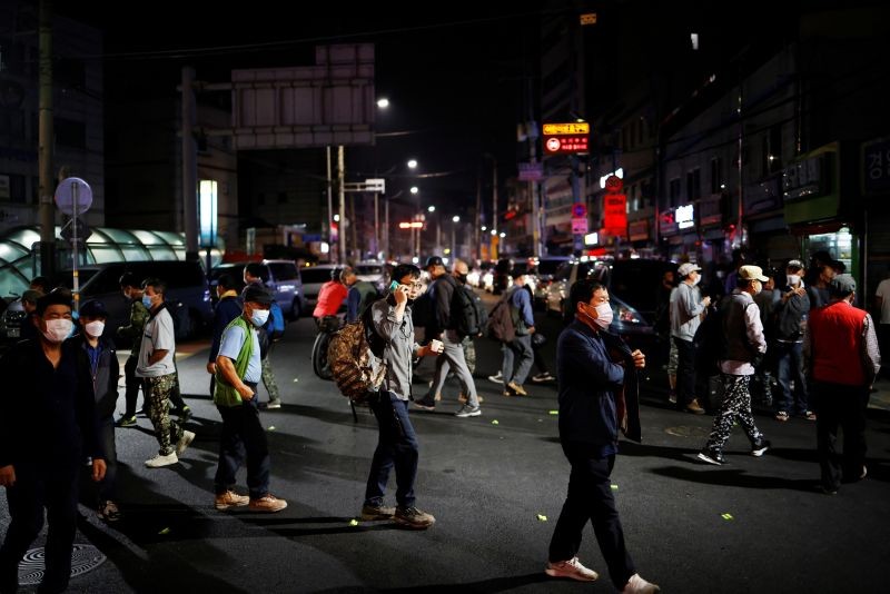 Day workers cross a road as they gather to seek for a job amid the coronavirus disease (COVID-19) pandemic, in the early morning near a day labour agency in Seoul, South Korea, September 17, 2020. (REUTERS File Photo)