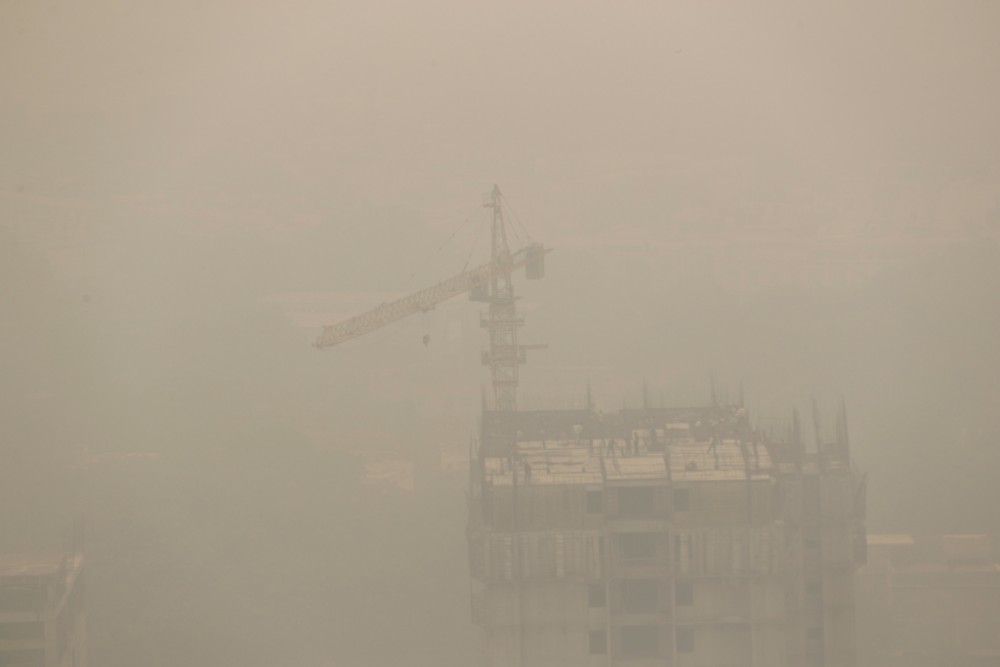 FILE PHOTO: Labourers work on top of a building under consideration amidst heavy smog in New Delhi, India, November 4, 2020. REUTERS/Adnan Abidi