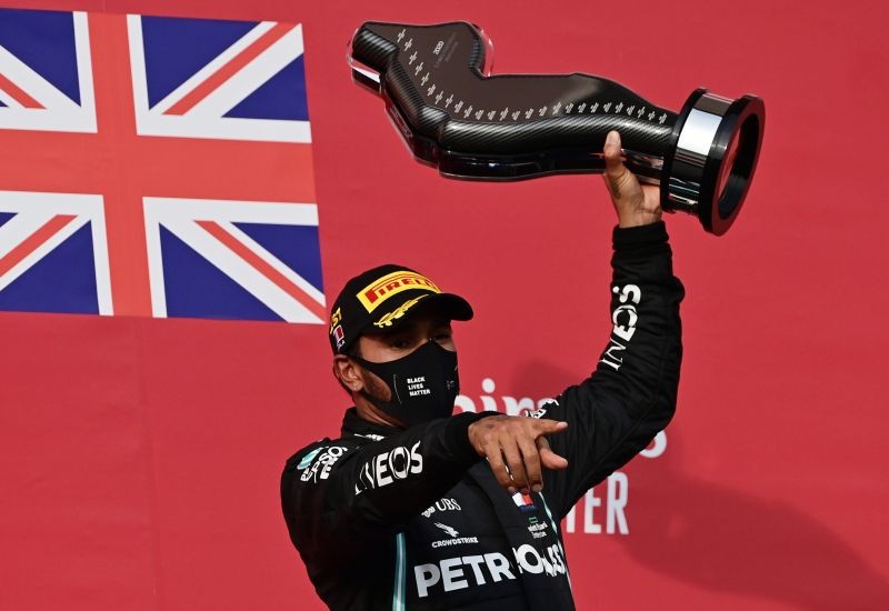Mercedes' Lewis Hamilton celebrates on the podium with the trophy after winning the race Pool via Reuters/Miguel Medina