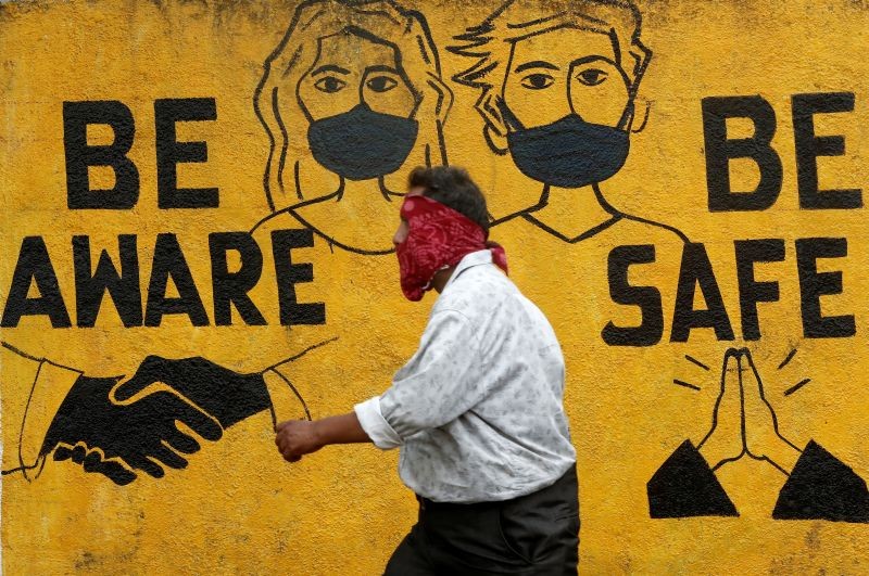 A man walks past a graffiti amid the spread of the coronavirus disease (COVID-19) in Mumbai, India, November 2, 2020. (REUTERS File Photo)