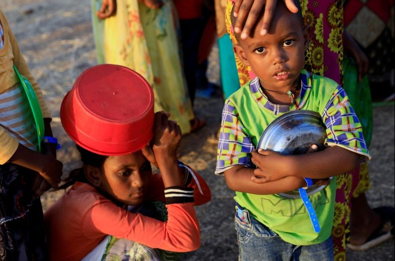 An Ethiopian child who fled war in Tigray region, carries his plate as he queues for wet food ration at the Um-Rakoba camp, on the Sudan-Ethiopia border in Al-Qadarif state, Sudan November 19, 2020. (REUTERS Photo)