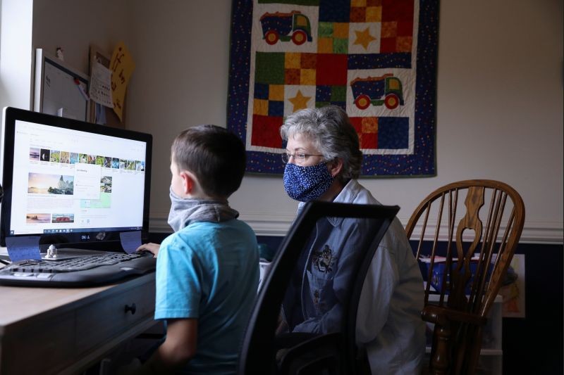 Bonnie Coughlin helps her grandson Caden with school work at their home in Gilbertsville, Pennsylvania, U.S., October 26, 2020. (REUTERS File Photo)