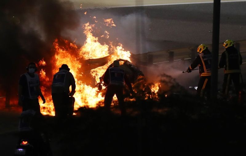 Stewards attempt to extinguish flames at the crash scene after Haas' Romain Grosjean crashed out at the start of the race Pool via REUTERS/Bryn Lennon
