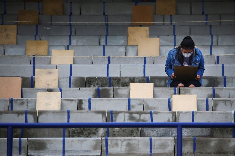 A woman wearing a protective face mask and a face shield holds social distancing as a measure to contain the spread of the coronavirus disease (COVID-19) before taking the entrance exam for Mexico's National Autonomous University in the stands of University Olympic Stadium in Mexico City, Mexico, August 19, 2020. (REUTERS File Photo)