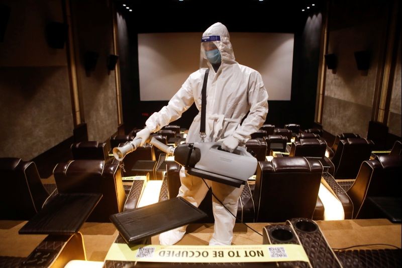 A man in personal protective equipment (PPE) sanitizes a cinema hall before a movie amid the spread of the coronavirus disease (COVID-19) in Mumbai, India November 15, 2020. (REUTERS Photo)
