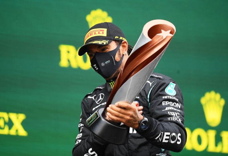 FILE PHOTO: Mercedes' Lewis Hamilton celebrates on the podium with a trophy after winning the race and the world championship Pool via REUTERS/Clive Mason/File Photo