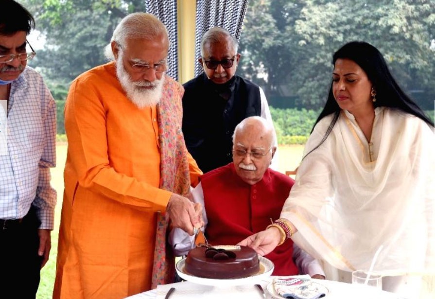 PM Modi helps Advani cut cake on his 93rd birthday. (IANS Photo)
