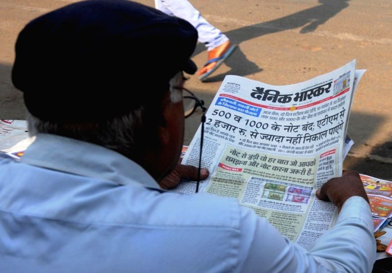 A man reads a newspaper regarding demonetisation of Rs 1000 and Rs 500 notes after Prime Minister Narendra Modi's announcement in Amritsar on November 9, 2016. (IANS File Photo)