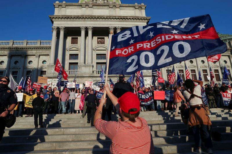 FILE PHOTO: Supporters of U.S. President Donald Trump rally as a supporter of Democratic presidential nominee Joe Biden celebrates outside the State Capitol building after news media declared Biden to be the winner of the 2020 U.S. presidential election, in Harrisburg, Pennsylvania, U.S., November 7, 2020. REUTERS/Leah Millis