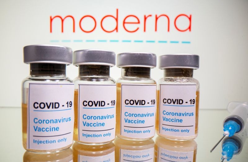 Vials with a sticker reading "COVID-19/Coronavirus vaccine/Injection only" and a syringe are seen in front of a displayed Moderna logo in this illustration taken October 31, 2020. (REUTERS File Photo)