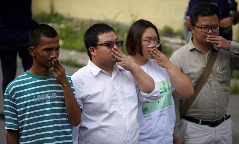 Panupong "Mike Rayong" Jadnok, Parit "Penguin" Chiwarak, Panusaya "Rung" Sithijirawattanakul and Arnon Nampa, a rights lawyer and protest leader, show the three-finger salute as they arrive to report themselves to police summons to acknowledge additional charges of Article 112 for actions deemed as insult to the monarchy, at a police station in Bangkok, Thailand, November 30, 2020. (REUTERS Photo)