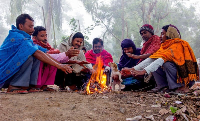 Nadia: People warm themselves near a bonfire during a cold morning, in Nadia district, Friday, Dec. 18, 2020. (PTI Photo)
