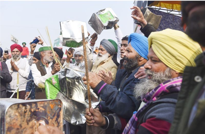 Farmers clap and beat cans at a protest against PM Modi's Man ki Baat programme, during their ongoing agitation over new farm laws, at Ghazipur border in New Delhi on December 27. (PTI Photo)