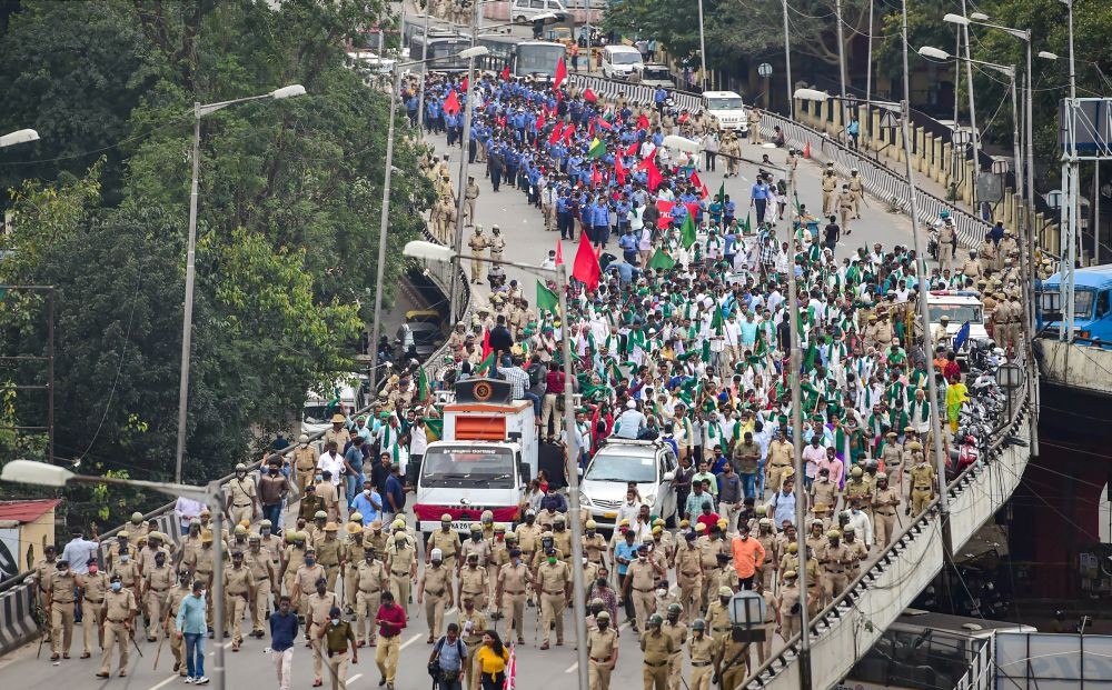 Police keep vigil as Karnataka farmers participate in a protest rally to press for repeal of the Centre's agri-laws, in Bengaluru, Wednesday, Dec. 9, 2020. (PTI Photo/Shailendra Bhojak)(
