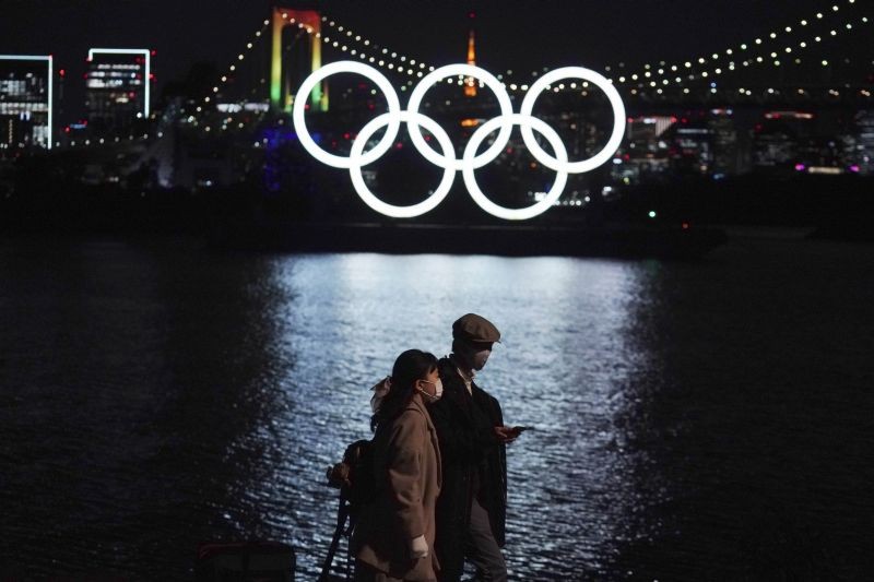 Tokyo: A man and a woman walk past near the Olympic rings floating in the water in the Odaiba section Tuesday, Dec. 1, 2020, in Tokyo. The Olympic Symbol was reinstalled after it was taken down for maintenance ahead of the postponed Tokyo 2020 Olympics.AP/PTI