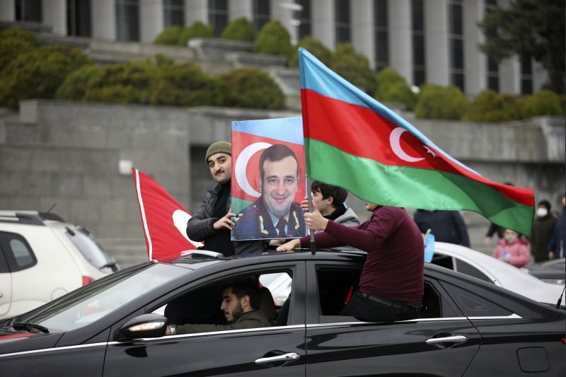 Azerbaijanis with national flags and a portrait of Azerbaijani Maj. Gen. Polad Hashimov, who was killed in fighting, celebrate returning their territories in Baku, Azerbaijan, Tuesday, Dec. 1, 2020. Azerbaijan has completed the return of the territories ceded by Armenia under a Russia-brokered peace deal that ended six weeks of fierce fighting over Nagorno-Karabakh. Azerbaijan's President Ilham Aliyev hailed the restoration of control over the Lachin region and other territories as a historic achievement. (AP/PTI Photo)