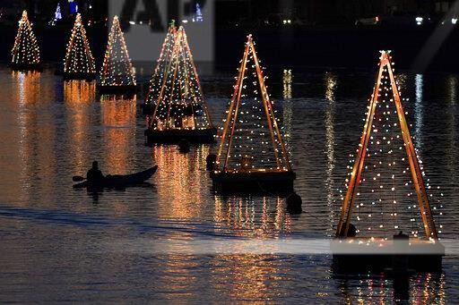 A kayaker paddles among holiday lights, Wednesday, Dec 16, 2020, in Long Beach, Calif. (AP Photo/Ashley Landis)