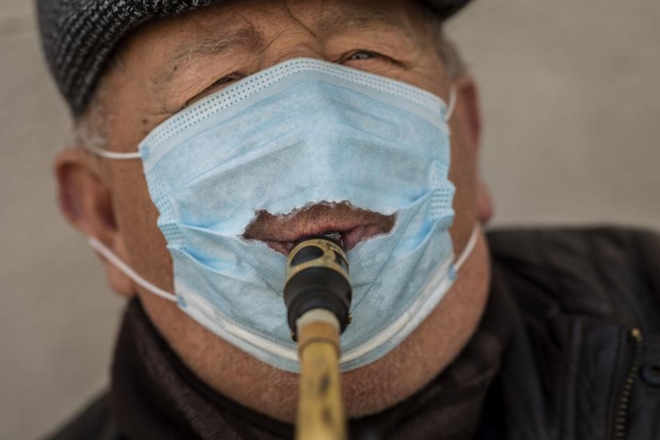 Street musician Roz Malin wears a face mask as he plays the saxophone in Madrid, Spain, Thursday, Dec. 17, 2020. (AP Photo/Bernat Armangue)