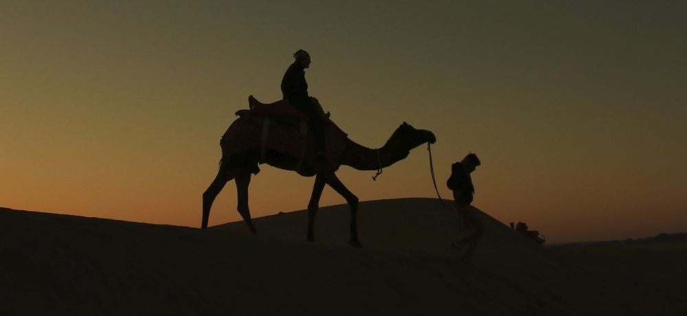 Jaisalmer: A tourist rides on a camel during sunrise at Thar desert in Jaisalmer, Monday, Dec. 14, 2020. (PTI Photo)