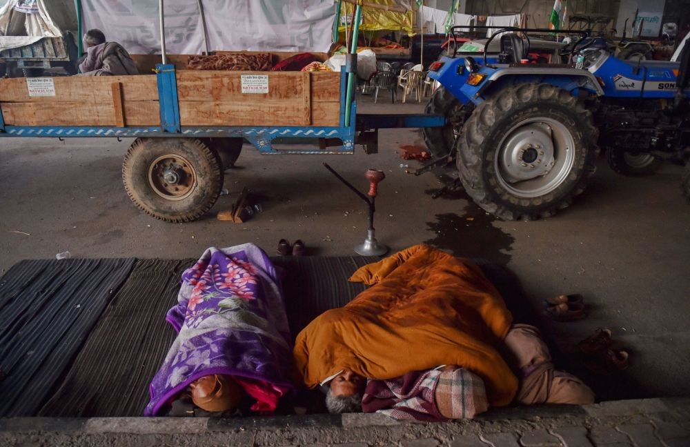 New Delhi: Farmers cover themselves with blankets on a cold morning during their sit-in protest against the Centre's farm reform laws, at Ghazipur border in New Delhi, Wednesday, Dec. 16, 2020. (PTI Photo/Manvender Vashist)