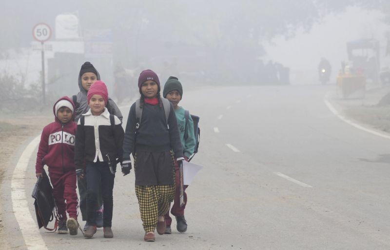 Amritsar: Children on their way to school amid dense fog during a cold winter morning, near Amritsar, Thursday, Dec. 17, 2020. (PTI Photo