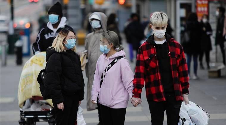Pedestrians wear personal protective equipment as they walk along Main Street. (AP File Photo)