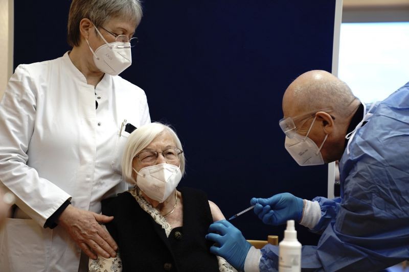 101-year-old Gertrud Haase, center, is vaccinated against the Corona virus at the Agaplesion Bethanien Sophienhaus nursing home in Berlin, Germany, by vaccinator Fatmir Dalladaku, right, and doctor Irmgard Landgraf on the left on December 27. (AP/PTI Photo)